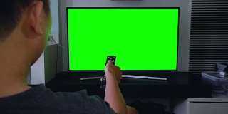 男人在客厅看绿屏电视