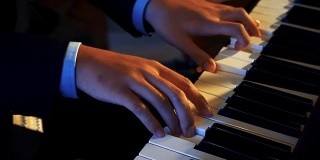 男子手在键盘上弹奏钢琴