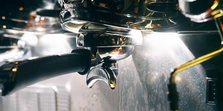 咖啡师把咖啡从机器滴到杯子里。