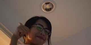 一个亚洲女人在自己房间里换灯泡，自己做