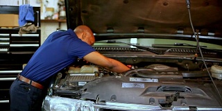 男，女机械师一起在汽车修理厂工作。