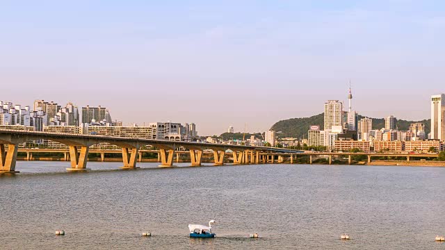 时光流逝的汉城和汉城塔从白天到晚上都有一座桥横跨汉江，韩国