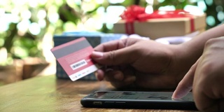 男人正在网上购物，用智能手机送礼物，用信用卡购物
