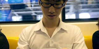 一名年轻人在火车上使用手机