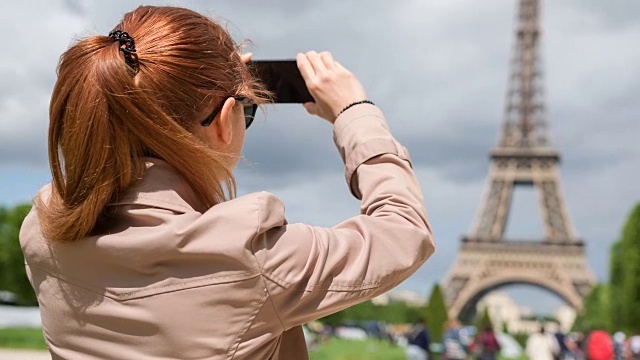 巴黎游客用智能手机拍摄埃菲尔铁塔