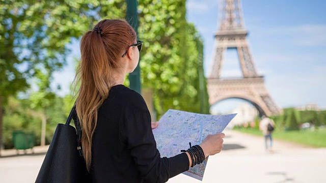 一名女子在巴黎旅游景点地图上看埃菲尔铁塔