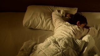 一名抑郁的女子因失眠躺在床上的镜头，快速移动视频素材模板下载