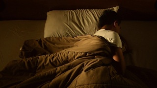 一名沮丧的男子因失眠躺在床上的画面视频素材模板下载