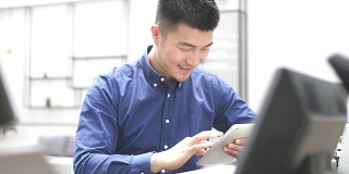 年轻的亚洲男子使用数字平板电脑