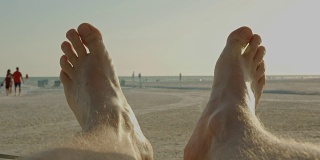男人脚的观点放松日落佛罗里达海滩夏天