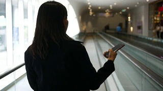 一名女子在走廊上玩手机视频素材模板下载