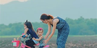 妈妈和她的女儿一起骑着自行车在乡下
