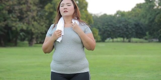 年轻的亚洲胖女人在公园里累了
