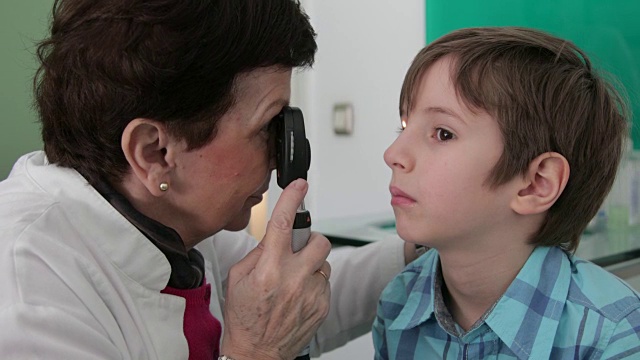 眼科医生正在检查小男孩的眼睛