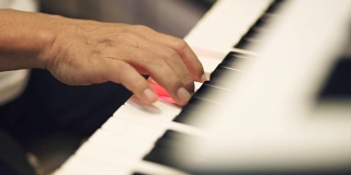 男人的手在弹奏钢琴键盘。