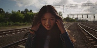 亚洲年轻女子在铁路上抛洒头发。