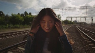 亚洲年轻女子在铁路上抛洒头发。视频素材模板下载