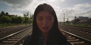 亚洲年轻女子在铁路上哭泣。