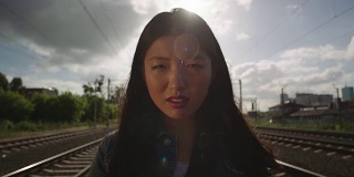亚洲年轻女子在铁路上哭泣。