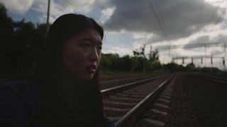 一个可悲的亚洲女人坐在火车上。视频素材模板下载