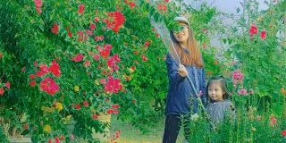 亚洲年轻母亲和女儿一起浇花