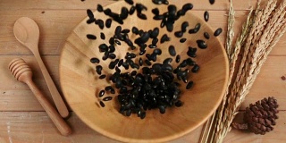 黑豆落入木碗中，慢镜头拍摄