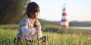 女孩快乐的在洋甘菊草坪上放松时光