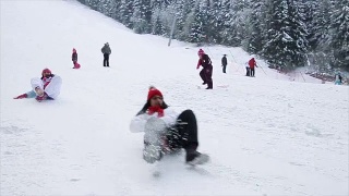 母女俩在冬季滑雪中心玩雪橇玩得很开心视频素材模板下载