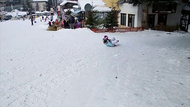 孩子们在冬季滑雪中心玩雪橇玩得很开心