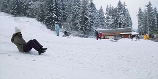 成年女子在冬季滑雪坡道上坐雪橇