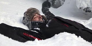 一个滑稽的人把自己扔在雪地里