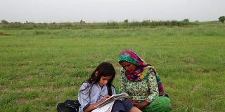 母亲和女儿在户外阅读的自然