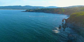 航拍的无人机飞过悬崖和海水，向旅游胜地