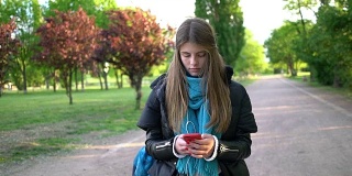 一个不开心的少女在城市公园发短信