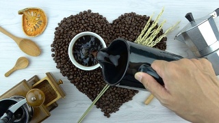 用咖啡杯烘烤成心形的咖啡豆视频素材模板下载