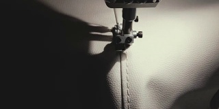 用缝纫机缝制白色皮革的过程。