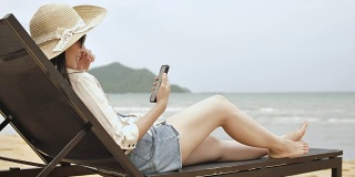 一个女人躺在沙滩上玩手机