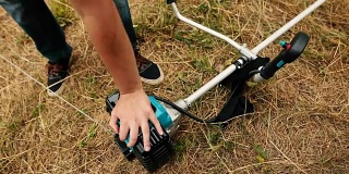 汽油草坪修剪机冷启动。专业割草机的手
