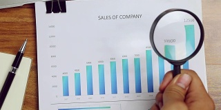 商人用放大镜分析他们的销售情况。