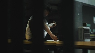 亚洲吉他作曲家是创作和头脑风暴的节奏音乐作曲家的工作过程视频素材模板下载