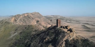 格鲁吉亚和阿塞拜疆边界上的古代防御工事的4K空中视频。美丽的沙质山谷景色。David Gareji修道院的一部分