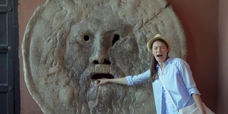 女人把手放在“真理之口”做鬼脸。女游客在意大利罗马享受假期