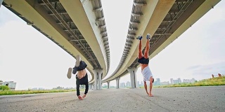 两个年轻人在桥下表演杂技