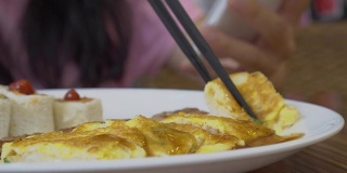 亚洲女人在酒店吃早餐。包括三文鱼煎蛋卷，汉堡，牙线，吐司，番茄酱。