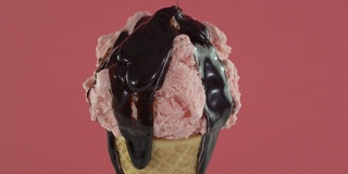 旋转草莓冰淇淋在蛋筒与巧克力酱