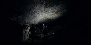 一群洞穴学家在黑暗的洞穴中行走