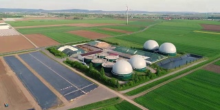 镜头从猪场的沼气厂上空飞过。生物质的可再生能源。现代农业欧盟。鸟瞰图，从空中俯瞰全景