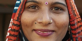 一个美丽的印度女人的脸的极端特写，微笑着，笑着，快乐着，快乐着，看着镜头，穿着传统服饰，头戴宾蒂，漂亮的珠宝，在家里，自由爱静态拍摄锁定