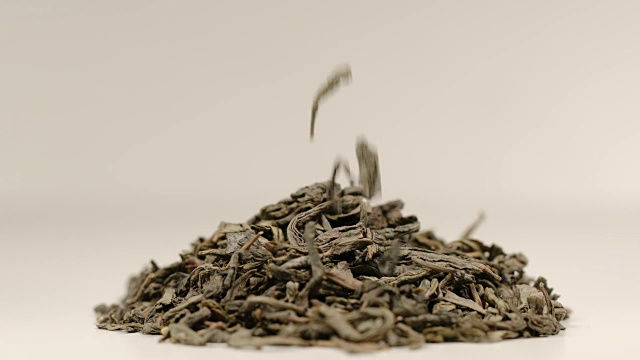 慢镜头:茶叶落在一堆绿茶上-微距镜头