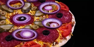 美味的披萨，配有泡菜、意大利腊肠、橄榄、奶酪、新鲜番茄和洋葱圈